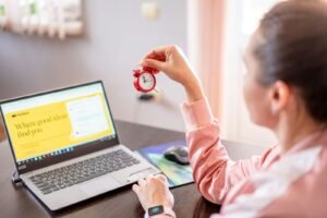Woman working productively at desk with laptop computer in bright modern office