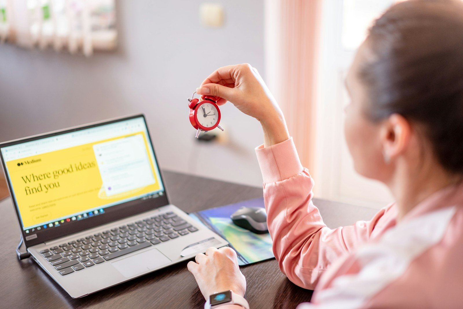 Woman working productively at desk with laptop computer in bright modern office